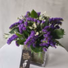 This elegant vase is filled with a beautiful arrangement of purple flowers. The arrangement is perfect for adding a touch of romance and sophistication to any home décor.